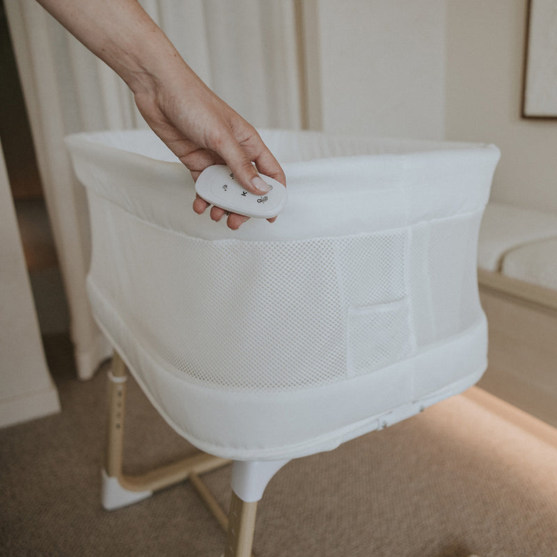 Person holding remote for BabyRest Swan Bassinet