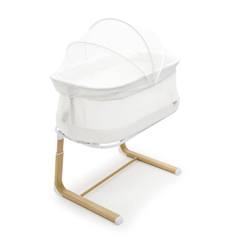 White bassinet with wooden legs on a white background